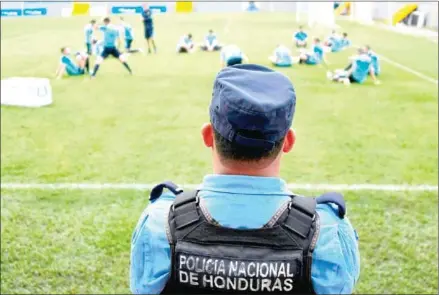  ?? ORLANDO SIERRA/AFP ?? A police officer stands guard as Australia train at Francisco Morazan stadium in San Pedro Sula on Tuesday ahead of the first leg of their 2018 World Cup qualifying playoff with Honduras on Friday.