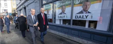  ?? Don’t look now: Fine Geal candidate Mike Kennelly and Tánaiste Simon Coveney pass a rival’s poster in Trale! Photo by Domnick Walsh ??