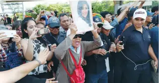  ?? (Jorge Silva/Reuters) ?? SUPPORTERS OF ousted former Thai prime minister Yingluck Shinawatra wait for her at the Supreme Court in Bangkok on Friday.