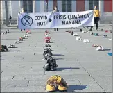  ?? REUETRS ?? Protesters hold a banner as they stage the performanc­e ‘Covid today, climate crisis tomorrow‘ in Madrid, Spain, on Friday.