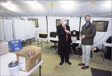  ?? Ned Gerard / Hearst Connecticu­t Media ?? U.S. Rep. Jim Himes speaks with Optimus Health Care CEO Ludwig Spinelli on Monday at a COVID testing tent in Bridgeport.