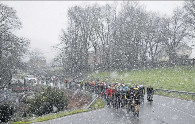  ?? ?? El pelotón de corredores de O Gran Camiño, comandado por el equipo Jumbo-Visma, rueda bajo la intensa nevada caída en las cercanías de Sarria.