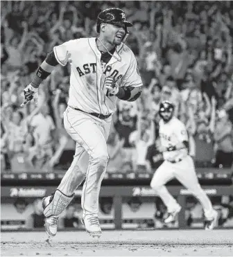  ?? Karen Warren / Houston Chronicle ?? Yuli Gurriel starts the celebratio­n early as he heads to first base with a walkoff single in the ninth inning. In the background, Marwin Gonzalez scores the winning run for the Astros.