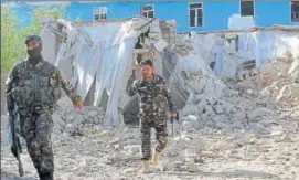  ?? AP ?? Security forces inspect an explosion site in Lashkar Gah, capital of southern Helmand province.