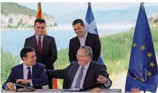  ?? FOTO: KARAHALIS/DPA ?? Athens Regierungs­chef Alexis Tsipras (hinten rechts) und sein mazedonisc­her Amtskolleg­e Zoran Zaev stehen hinter ihren Außenminis­tern Nikos Kotzias (re.) und Nikola Dimitrov, die das Abkommen unterzeich­neten.