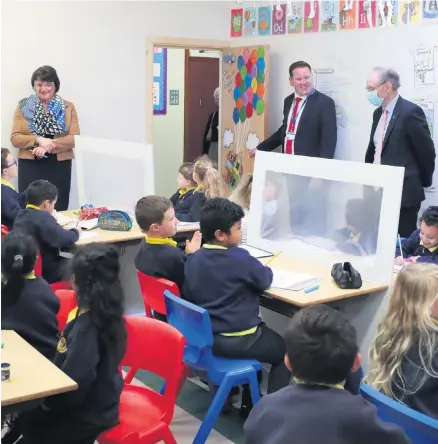  ?? PRESSEYE ?? School visit: Education Minister Peter Weir (in mask) and First Minister Arlene Foster chat to pupils at Dungannon Primary School as head David Thompson looks on