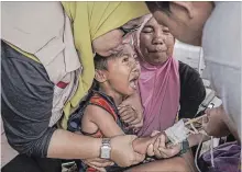  ?? ULET IFANSASTI GETTY IMAGES ?? A boy cries while receiving treatment at an emergency hospital in Lombok Island, Indonesia, on Friday.