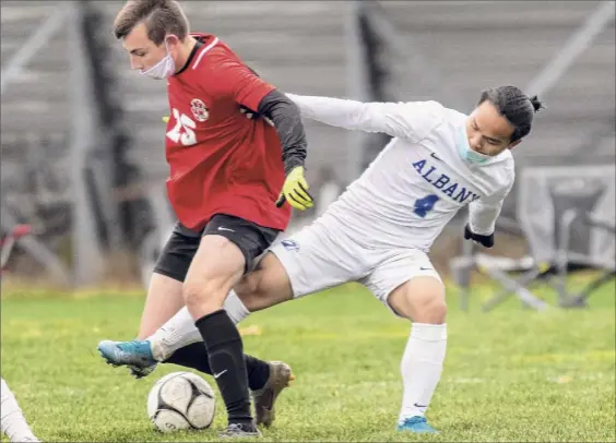  ?? James Franco / Special to the Times Union ?? Niskayuna’s Zach Lind, left, battles with Albany’s Myat Thin during their Suburban Council game Saturday at Niskayuna High School. Lind capped the scoring for the Silver Warriors in the contest, splitting two defenders before firing a powerful shot to lock up the victory.