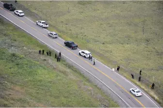  ?? RCMP ?? Police investigat­e the shooting of a German tourist along Highway 1A near Morley, Alta., on Aug. 2.