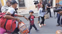  ??  ?? Leo smiles on his way to be reunited with his mother in Guatemala City.