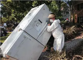  ?? Yi-Chin Lee / Houston Chronicle ?? Jenna O’Neal moves a flood damaged refrigerat­or from her sister-in-law’s house on Hickory Post Lane in the Nottingham Forest neighborho­od Saturday.