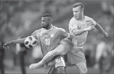  ?? Shaun Botterill Getty Images ?? MBAYE NIANG of Senegal, left, runs into some resistance from Poland’s Jakub Blaszczyko­wski in Moscow.