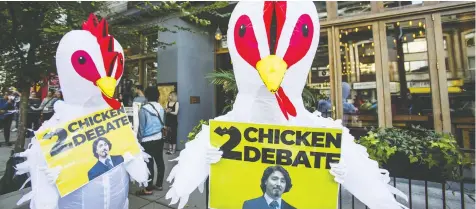  ?? ERNEST DOROSZUK / THE CANADIAN PRESS ?? Two people in chicken costumes outside of a Liberal Party of Canada fundraiser last week. The costumes were used by the Conservati­ve campaign
to accuse Prime Minister Justin Trudeau of being too afraid to attend all the debates.