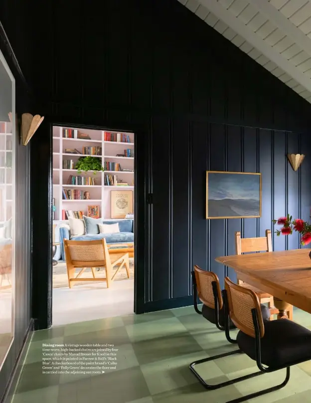  ??  ?? Dining room A vintage wooden table and two time-worn, high-backed chairs are joined by four ‘Cesca’ chairs by Marcel Breuer for Knoll in this space, which is painted in Farrow & Ball’s ‘Black Blue’. A checkerboa­rd of the paint brand’s ‘Calke Green’ and ‘Folly Green’ decorates the floor and is carried into the adjoining sun room