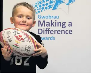  ??  ?? Iuestyn proudly shows off his signed Wales rugby ball