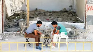  ??  ?? People play chess on Tuesday in the southern town of Bosra Al-Sham, Deraa Governorat­e, Syria. (Reuters)