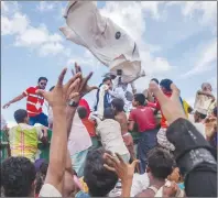  ?? AP PHOTO ?? Rohingya Muslim children, who recently crossed over from Myanmar into Bangladesh, reach out to catch clothes thrown toward them by locals near Balukhali refugee camp in Bangladesh.