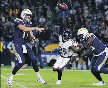  ?? — GETTY IMAGES ?? Chargers quarterbac­k Philip Rivers dishes off during Los Angeles’ 22-10 loss to the Ravens on Dec. 22. Rivers was limited to 181 yards passing with two intercepti­ons.