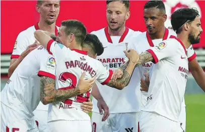  ?? EFE ?? Ocampos y el Papu Gómez se abrazan tras uno de los dos goles que el Sevilla le marcó al Granada