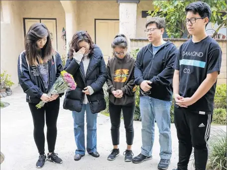  ?? Irfan Khan Los Angeles Times ?? DANIEL OH, 13, right, and his family pray at the Arcadia home where his friend Anthony Lin, 15, and Anthony’s brother, William Lin, 16, were killed last week. The brothers, who attended Arcadia High School, had suffered blunt-force trauma to their...