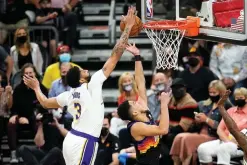  ?? AP Photo/Ross D. Franklin ?? ■ Los Angeles Lakers forward Anthony Davis, left, blocks the shot of Phoenix Suns guard Devin Booker, right, during the first half of Game 1 of their NBA first-round playoff series Sunday in Phoenix.