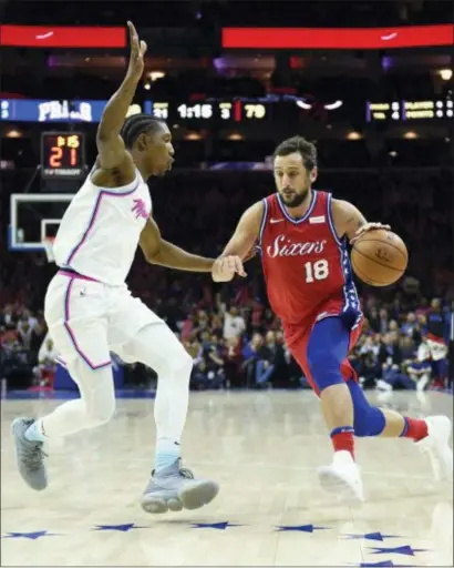  ?? MICHAEL PEREZ — THE ASSOCIATED PRESS ?? Marco Belinelli, right, drives to the basket past Miami’s Josh Richardson Wednesday night. 17 points in his Sixers debut, a 104-102 win over the Heat. Belinelli scored