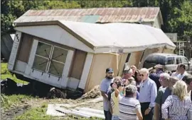  ?? Evan Vucci Associated Press ?? PRESIDENT BIDEN on Monday tours a neighborho­od damaged by f looding in Lost Creek, Ky. More thundersto­rms are expected in the area through Thursday.