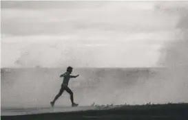  ?? ASHLEE REZIN/SUN-TIMES ?? A jogger gets hit with a wave on the Lakefront Trail near West Fullerton Avenue in October 2021 on a day of high winds. Fearing the man might be swept into the lake, photograph­er Ashlee Rezin yelled at him — and “wasn’t polite about it.”