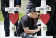  ?? MARK HUMPHREY — THE ASSOCIATED PRESS ?? Joe Perez Sr., of Austin, Texas, writes a message on a wooden cross memorial for shooting victim Akilah DaSilva at a Waffle House restaurant Wednesday in Nashville, Tenn. Perez’s son, Joe Perez Jr., was one of four victims killed at the restaurant by a...