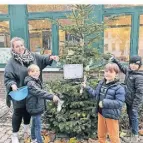  ?? FOTO: JUGENDCAFÉ BAMM ?? Cerise Beermann und Kinder hängen kleine Aufmerksam­keiten an den Baum .