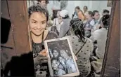  ?? LINH PHAM/GETTY ?? A relative shows a photo of boys who had been missing in Thailand for days before rescuers located them Monday.