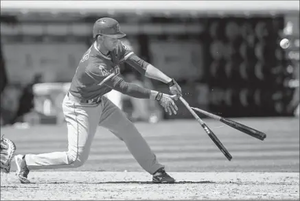  ?? Jason O. Watson Getty Images ?? ANDRELTON SIMMONS’ bat comes apart as he’s out on a popup in the fifth inning at Oakland. The Angels shortstop made good on an eighth-inning opportunit­y at the plate, hitting a single that scored Kole Calhoun.