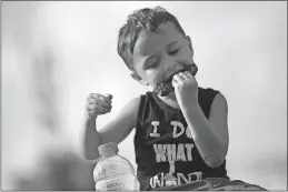  ??  ?? Josiah Pacas, 4, of Reynoldsbu­rg takes a big bite of ribs. He’s been coming to the Jazz & Rib Fest since he was a baby.