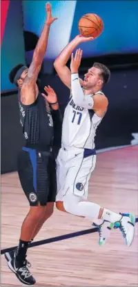  ??  ?? Morris intenta taponar el lanzamient­o de Doncic.