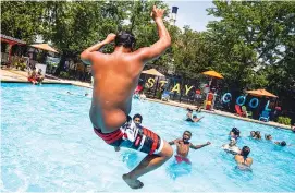  ?? BRITTAINY NEWMAN/THE NEW YORK TIMES ?? Ceasar Soto, 15, jumps into the public pool on Avenue D in New York on Friday. Across the sweaty landscape of the United States, people are beating the heat any way they can during a massive heat wave.