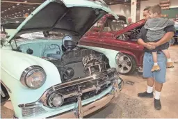  ?? CHAVEZ/THE REPUBLIC
CARLOS ?? Ted Torrez and his 3-year-old son Simmon check out a 1953 Chevy 210 at the Arizona Super Show in 2004.