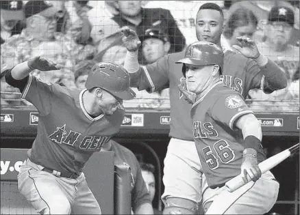  ?? Photograph­s by Eric Christian Smith Associated Press ?? ANDRELTON SIMMONS, left, celebrates with Kole Calhoun after Simmons’ three-run homer in the seventh inning against Houston reliever Joe Smith gave the Angels an 8-5 lead. Simmons also hit a solo home run in the second inning.