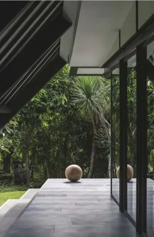  ?? ?? In the walkway outside Maximilian Eicke’s parents’ bedroom in his Bali retreat (page 150), hand-carved reclaimed teak sphere sculpture by Maximilian Eicke; floor tiles from Niro Granite. Details, last pages.