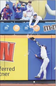  ?? Seth Wenig / Associated Press ?? A fan spills beer on Brewers left fielder Ryan Braun as he tries but fails to grab a triple by the Mets’ Pete Alonso in the first inning Sunday.