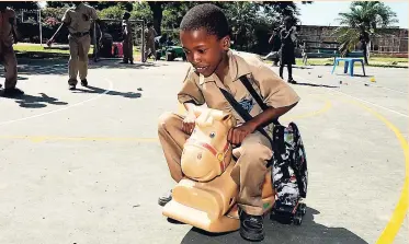  ?? LIONEL ROOKWOOD ?? This youngster, who attends the Seaward Primary School, rides a toy horse during PlayMatter­sJA that was held at the Maxfield Park Children’s Home in St Andrew on Tuesday.