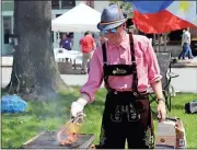  ??  ?? Spencer Lahr / Rome News-Tribune
Thomas Kislat, of the Greater Rome Convention and Visitors Bureau, wears lederhosen while he cooks bratwursts during Saturday’s Internatio­nal Festival on Broad Street.