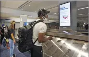  ?? KATHY WILLENS - ASSOCIATED PRESS ?? Arriving passengers await their bags in the baggage claim area at LaGuardia Airport’s Terminal B baggage claim area Thursday in New York.