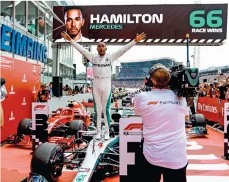  ??  ?? Lewis Hamilton, el campeón defensor del título, festeja en el circuito alemán de Hockenheim, al triunfar en una carrera en la que largó desde atrás y superó a todos los autos que lo precedían.