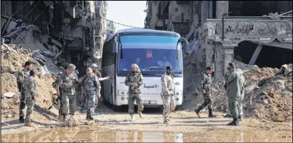  ?? SANA/AP PHOTO ?? In this file photo, Syrian government forces oversee a bus carrying al-qaida-linked fighters during an evacuation from the Palestinia­n refugee camp of Yarmouk, near Damascus, Syria. Syria’s military said Monday that it has liberated the last...