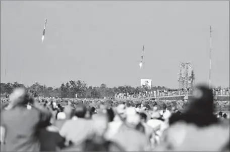  ?? Malcolm Denemark Florida Today ?? CROWDS on the beach in Cape Canaveral, Fla., watch the landing of two of the three boosters from SpaceX’s Falcon Heavy rocket.