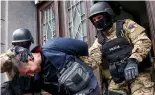  ?? ?? Members of the special police unit of Canton Sarajevo escort a person arrested in an operation codenamed "Black Tie" in Sarajevo, Bosnia, Monday, April 22, 2024