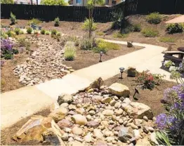  ?? PATRICIA WOOD OTAY WATER DISTRICT ?? A garden path crosses the stone-lined dry creek bed, accented by solar lights.