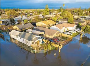  ?? Photograph­s BY NOAH BERGER Associated Press ?? PLANADA in Merced County is flooded Jan. 10. Storms that pummeled California for weeks inflicted extensive damage to as many as 40 of the state’s 58 counties, the Governor’s Office of Emergency Services says.