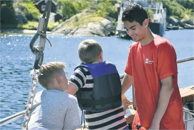  ?? FOTO: BJØRN RUNAR FOSS SODELAND ?? FERIE FOR ALLE: Frivillig-leder og ferievert Nawras Bin Khadra (17) med to av guttene om bord båten Flesa.