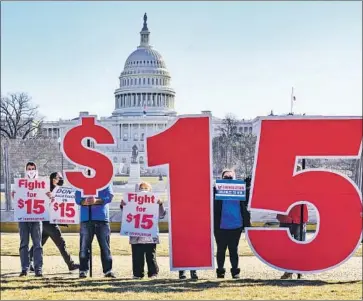  ?? J. Scott Applewhite Associated Press ?? ACTIVISTS appeal for a $15 minimum wage this week near the Capitol in Washington. The COVID-19 relief bill was expected to pass the House early Saturday on a nearly party-line vote before heading to the Senate.